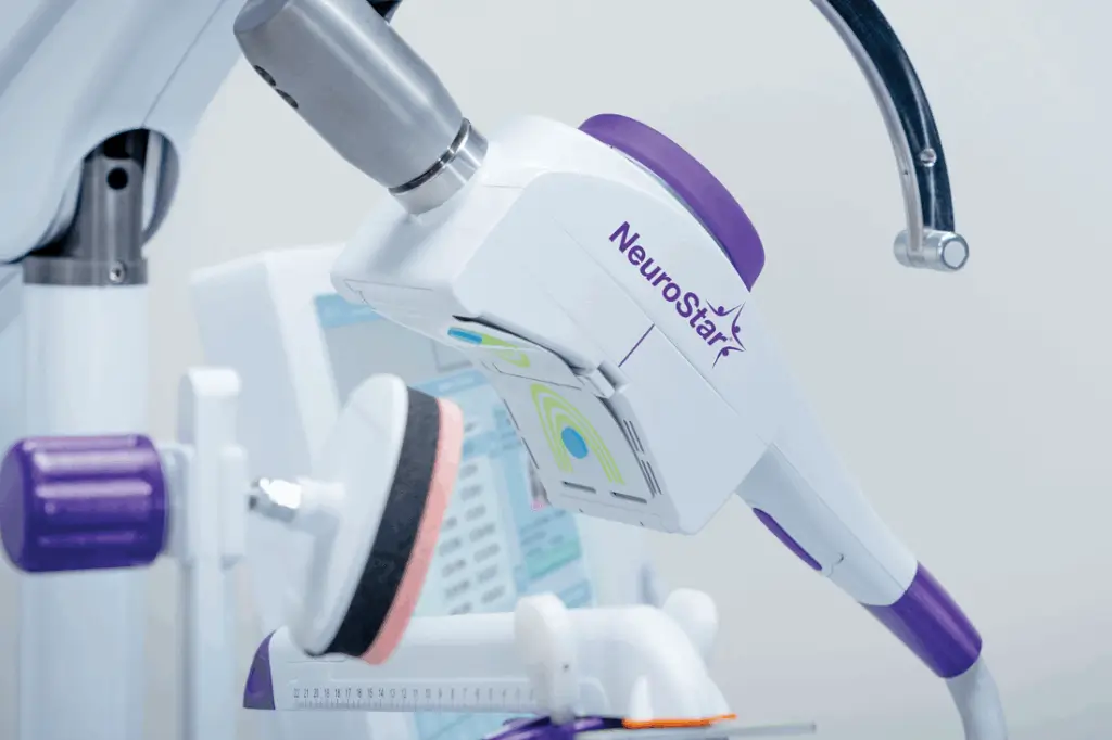 The image showcases a TMS system, a non-invasive brain stimulation therapy that may be utilized to address various neurological or psychiatric disorders.