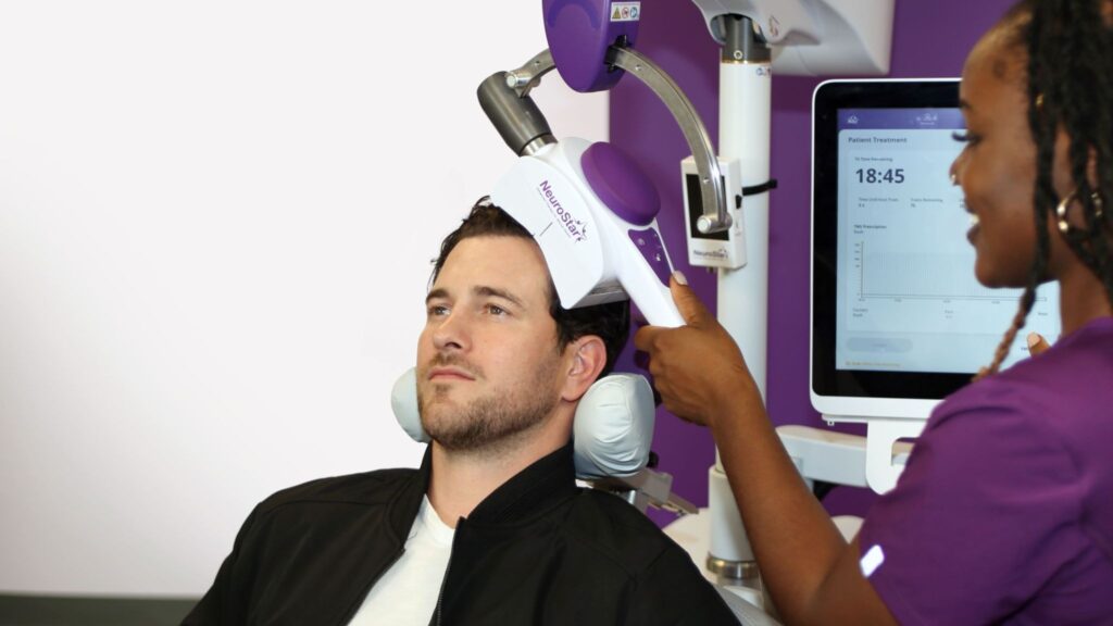Male patient undergoing NeuroStar session proving Is TMS FDA-Approved For Depression with technician present