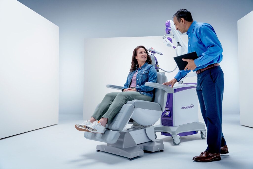 A doctor guides a patient through TMS treatment, addressing concerns like can depression come back after TMS. 