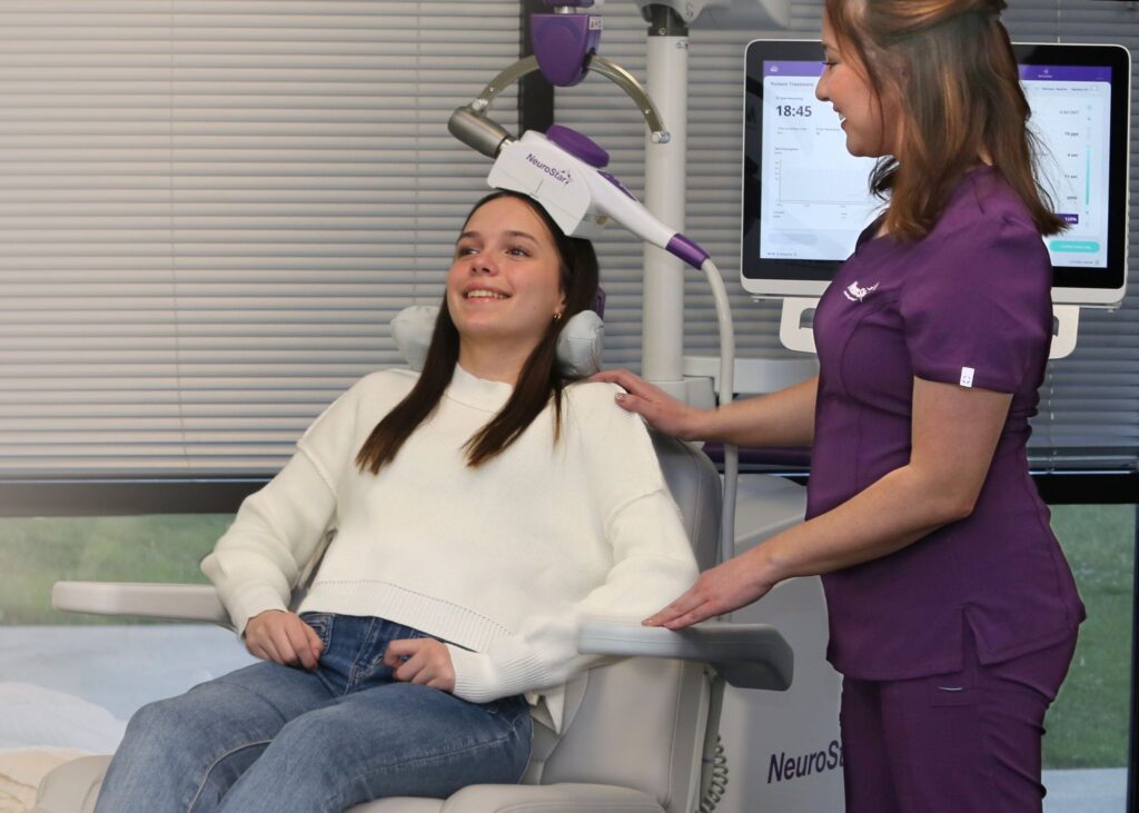 A smiling teen receives NeuroStar TMS therapy, showing hope for those asking can depression come back after TMS. 