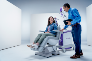 Patient relaxes in a NeuroStar chair while a clinician monitors transcranial magnetic stimulation.